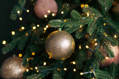 Yeni yıl oyuncağı. Bulanık, ışıl ışıl ve muhteşem bir arka planda dekore edilmiş Noel ağacı. Garland ve Bokeh. Parlak Işıklar.