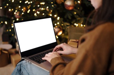 Kadın dizüstü bilgisayarda çalışıyor. Boş ekran ve taklit alanı var. Çevrimiçi alışveriş kavramı, indirimler veya uzaktan internet iletişimi.