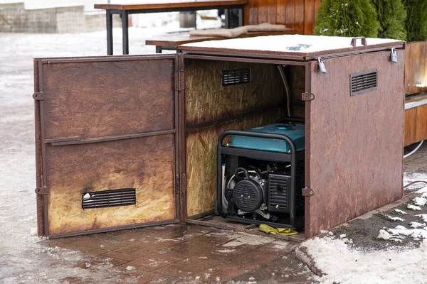 Portable electric generator running in the cold winter.Energy genocide. Power outage as a result of missile strikes by Russia on energy facilities of Ukraine. Small business use gasoline generators