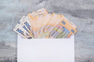 Taştan bir arka planda beyaz bir zarfın içinde Ukrayna Hrivnia 'sı. Uzayın kopyası. 500 hryvnias. Ödeme veya yolsuzluk kavramı.