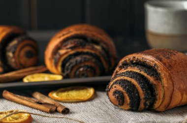 Haşhaş tohumlu çörekler ve koyu ahşap arka planda bir fincan kahve..