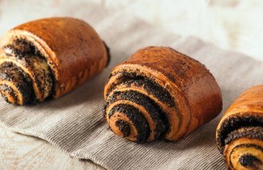 Açık arkaplanda haşhaş tohumlu çörekler.