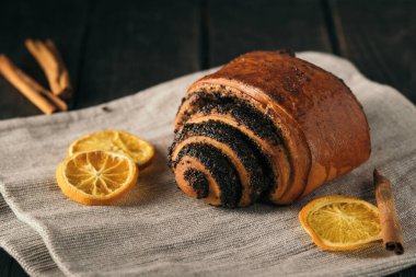 buns with poppy seeds on dark wood background with napkin.