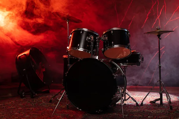 Drums and drum set. Beautiful blue and red background, with rays of light. Beautiful special effects of smoke and lighting. Musical instrument. The concept of music.