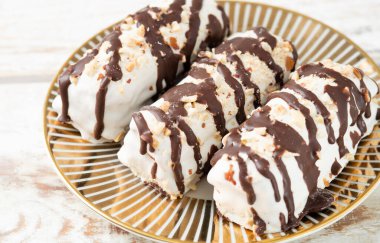 butter cookies dessert covered in chocolate and walnut glaze on gray table.