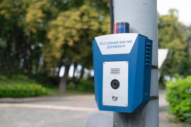 Şehir parkında acil durum düğmesi. SOS, polis, panik. İnsanların güvenliği konsepti. Acil yardım çağrısı.