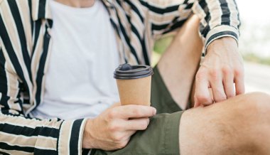 Elinde siyah bir kapak olan kağıt bardak. Yaklaş, kahve fincanı, maket. konsepti kaldır.