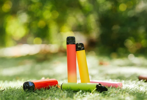 Set Colorful Disposable Electronic Cigarettes Green Grass Sun Rays Blur Royalty Free Stock Images