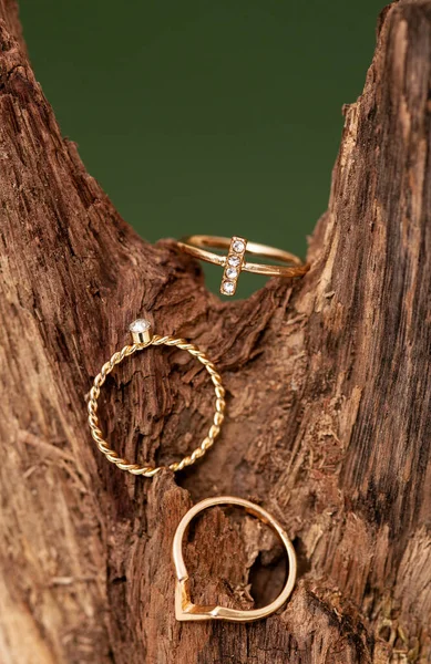 Stijlvolle Gouden Ringen Houten Tak Beige Ondergrond Sieraden Mode Fotografie — Stockfoto