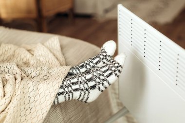 Kadın çorapları içinde, elektrikli ısıtıcının önünde. Kapatın. Soğuk ısıtma mevsimi. Yüksek kalite fotoğraf