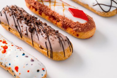 Beyaz tabakta orijinal krema dekoru olan nefis Fransız ekleriydi. Lezzetli tatlı profiterolleri 