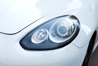 Kyiv, Ukrayna - 11.04 2024 Lüks beyaz Porsche 'nin farlarını kapatın. Makinenin farları
