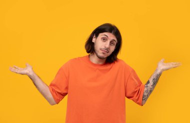 Uzun saçlı, sıradan kıyafetler giyen, kafası karışık ve kafası karışık genç, orta doğulu bir adam. şüphe kavramı.