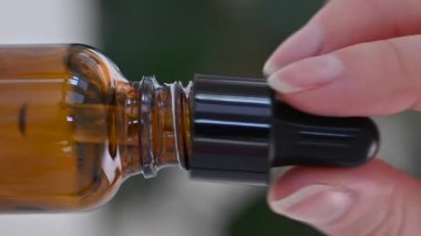 Masaj için kozmetik yağlı boru ve damlalar kahverengi bir şişeye akıyor, yakın plan..
