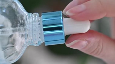  Pipetten damlayan bir damla beyaz arka planda cam bir şişeye damlıyor. Makro Yavaş Çekim.