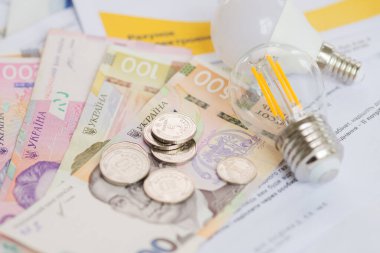 Ukrayna parası, Hryvnialar ve ampuller. Ukrayna 'da elektrik faturaları ve artan elektrik fiyatları konsepti. Elektrik maliyetleri. 