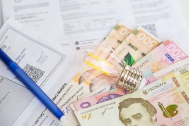 Ukrayna parası, Hryvnialar ve ampuller. Ukrayna 'da elektrik faturaları ve artan elektrik fiyatları konsepti. Elektrik maliyetleri. 