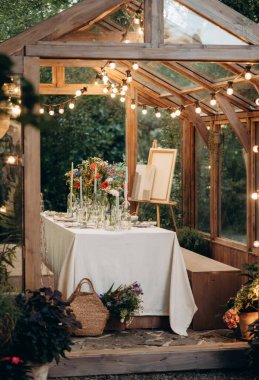 Akşam yemeği masası, mumlar ve mum ışıkları olan modaya uygun bir sera.