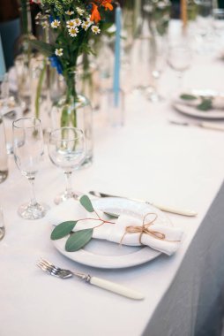 Masa seti boş beyaz tabakta peçete, şarap bardakları ve çatal bıçak takımı, kopyalama alanı. Düğün resepsiyonunda. Ziyafet için servis edilen masa.