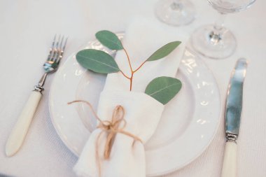 Masa seti boş beyaz tabakta peçete, şarap bardakları ve çatal bıçak takımı, kopyalama alanı. Düğün resepsiyonunda. Ziyafet için servis edilen masa.