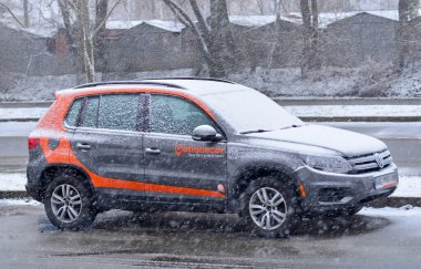 Kyiv - Ukrayna, Ocak 2024 - Kar yağışı sırasında, Getmancar araba kiralama servisinden bir araba yolda duruyor. 