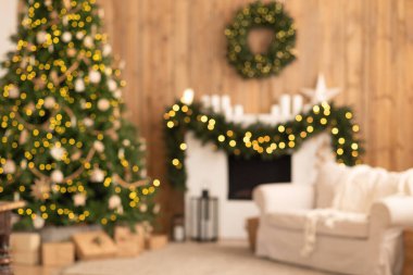 Süslü bir ağacı olan bulanık bir Noel oturma odası şöminede çelenk ve festival ışıkları, sıcak bir tatil atmosferi yaratıyor..