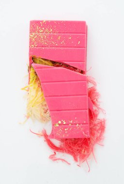 Kırık pembe çikolata, beyaz arka planda yalıtılmış lifli dolgu. Pembe pismaniye. Modaya uygun şekerler. melek saçı. 