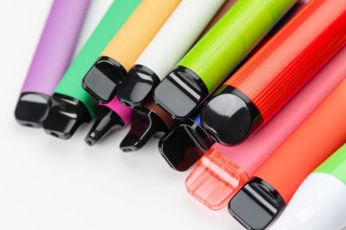 Renkli tek kullanımlık vapurlar çeşitli parlak renklerde modern elektronik sigara içme cihazları dizildi 