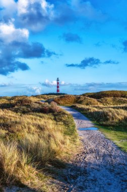 Hollanda, Ameland 'daki deniz fenerine giden yol kum tepelerinden geçiyor.