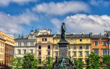 Krakow, Poland - 12 August 2022: The Adamowi Mickiewiczowi Narod (Adam Mickiewicz Monument) in the main market square in the Old Town of Krakow in Poland. It is a bronze monument unveiled in 1898