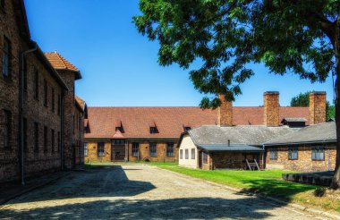 Oswiecim, Poland- 15 August 2022: Roof with a row of brick chimneys and back side of the kitchen building in Auschwitz I
