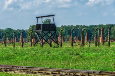 Electric fence with barbed wire and watchtower at the Auschwitz-Birkenau concentration camp in Oswiecim, Poland. Europe.