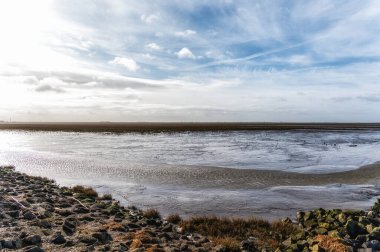 Wadden Denizi 'nin çamurlu düzlüğü. Düşük gelgitte UNESCO Dünya Mirası sahası. Holwerd, Hollanda.