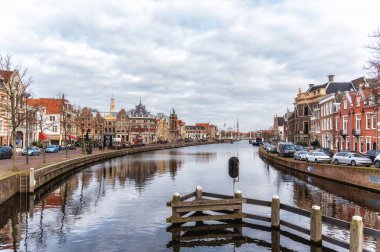 Hollanda, Haarlem şehrinde sıralı eski evleri ve tartı evi olan Spaarne Nehri