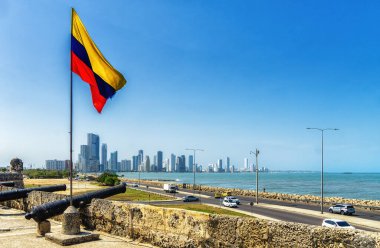 Columbian flag and cannon,  view of Cartagena in the background clipart