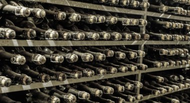 Bira fabrikasının bira mahzeninde tozla kaplı eski bira şişeleri.