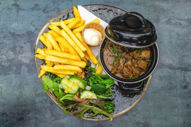 Ekşi etin (Felemenkçe: Zuurvlees) patates kızartması (friet veya patat) ve karışık salata ile sunulduğu en iyi manzara, hem Hollanda hem de Belçika 'da bulunan Limburg' dan gelen bölgesel et yemeğidir..