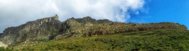 Cape Town, Güney Afrika 'da açık mavi bir gökyüzünün altındaki kayalık bir dağ sırasının panoramik görüntüsü