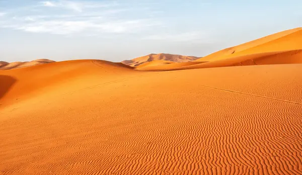 Mavi gökyüzü olan çöl manzaraları. Yuvarlak şekilli kum tepecikleri. Doğal değişimlerin güzelliği.