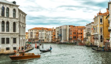 Venedik, İtalya - 10 Haziran 2022: Gondolcu Venedik, İtalya 'da gondolda turistleri taşıyor. Geleneksel Venedik gondolu ünlü kanalda. Güzel Venedik manzarası.