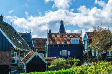 Hollanda 'nın küçük Marken kasabasında güneşli bir bahar gününde eski Hollanda, Hollanda' da bulunan ahşap evlerle yürüyorum.