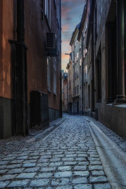 Stockholm 'ün tarihi Gamla Stan' inin (Eski Şehir) Stockholm merkez Stockholm, İsveç 'te alacakaranlıkta mavi saatte aydınlattığı güzel sokaktaki geleneksel evlerin klasik alacakaranlık manzarası.