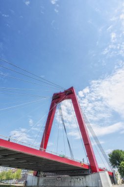 A view at the Willemsbrug, a cable-stayed red bridge with a total span of about 318 meters, Rotterdam, The Netherlands clipart