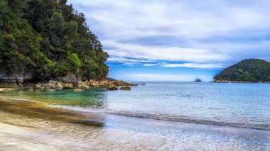 Kayalar, kumsal ve yemyeşil yağmur ormanları içeren manzara, Torrent körfezinde, Kaiteriteri yakınlarında, Abel Tasman Parkı, Güney Adası, Yeni Zelanda