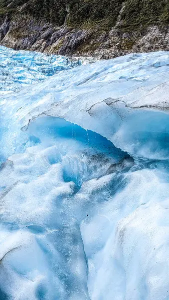 stock image Parts of the fox glacier in New Zealand with deeply hanging clouds and crest.