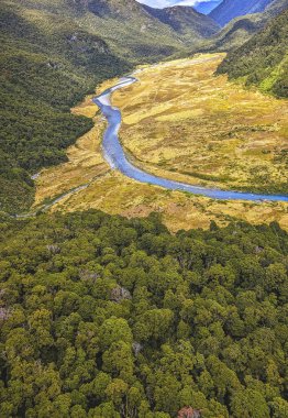 Aerial of green glades, forest and pebbly riverbed at Wilkin river, shot in bright spring light from above, Otago, South Island, New Zealand clipart