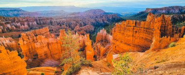 Dramatik gökyüzü ve mavi gökyüzü, Utah, Abd ile gün doğumunda güzel altın sabah ışığında doğal Bryce Canyon Milli Parkı'nda şaşırtıcı hoodoos kumtaşı oluşumları Panoramik görünümü