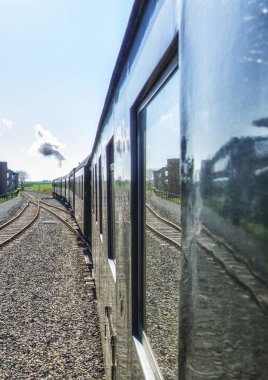 Small steam tram locomotive driving through the Dutch countryside, looking out the window view, nostalgic summer tourist attraction in The Netherlands clipart