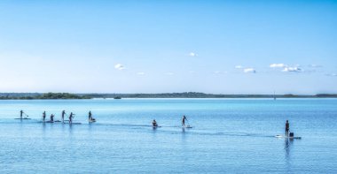 Bacalar, Meksika - 27 Şubat 2024: Quintana Roo, Meksika 'da Bacalar lagünündeki kürek sörfü. Sakin sularla