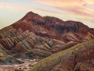 Gökkuşağı Dağı 'nın muhteşem manzarası ve gün batımında mavi gökyüzü arkaplanı. Zhangye Danxia National Geopark, Gansu, Çin. Renkli manzara, gökkuşağı tepeleri, sıra dışı renkli kayalar, kumtaşı erozyonu.